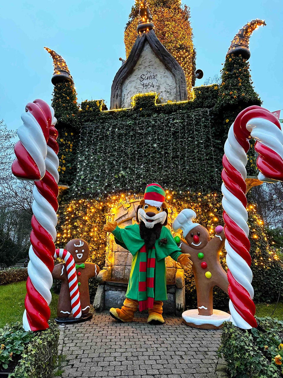 Koning Leeuw naast peperkoekmannetjes, tussen zuurstokken en voor het verlichte bloemenkasteel tijdens Kerst.